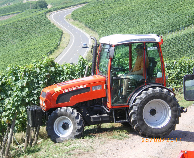 Traktor im Hang mit Mulcher Traktor fährt an Hanglage mit montiertem Mulchgerät